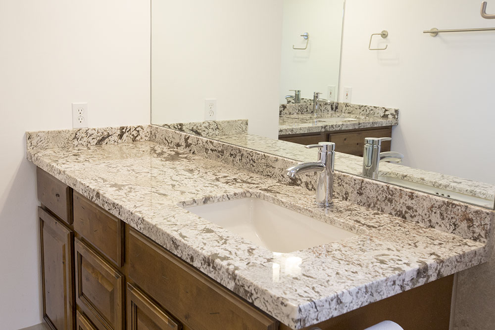 This modern bathroom includes square bowl sinks and single pull faucets