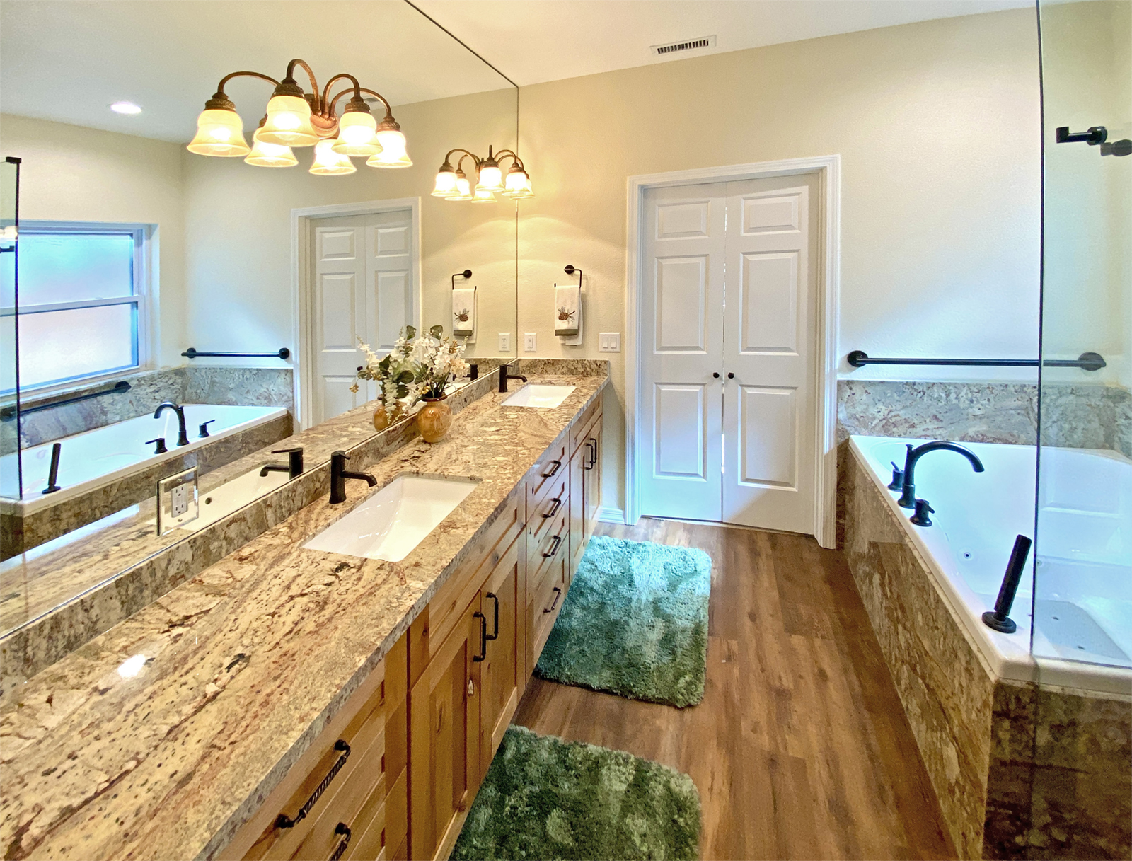 Master bathroom with granite counters, rustic cherry cabinets, jetted tub, full height mirror and frameless shower door.