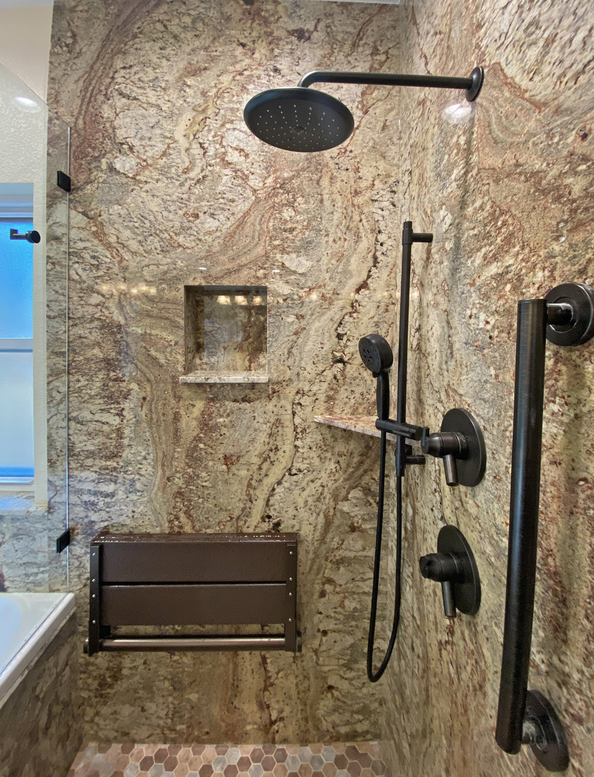 ADA style shower featuring a fold down seat, grab bar and shower wand.