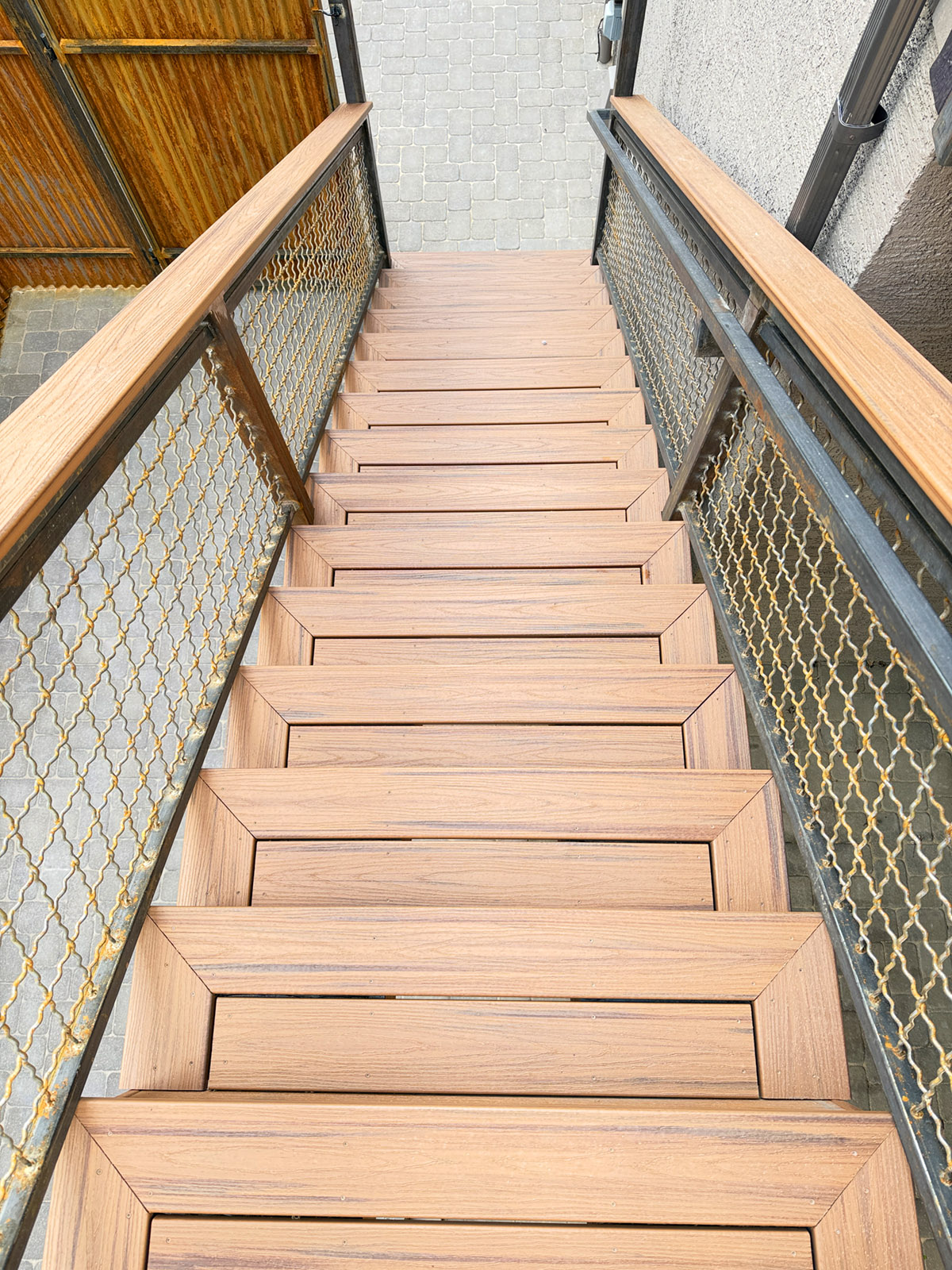 Deck stairs made with pictured framed steps and a rusted metal railing.  Trex composite deck boards.