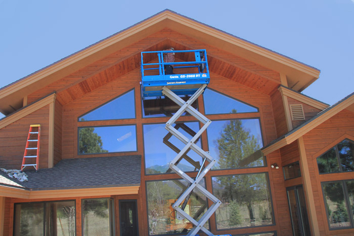 House Staining Staining a house on a scissor lift