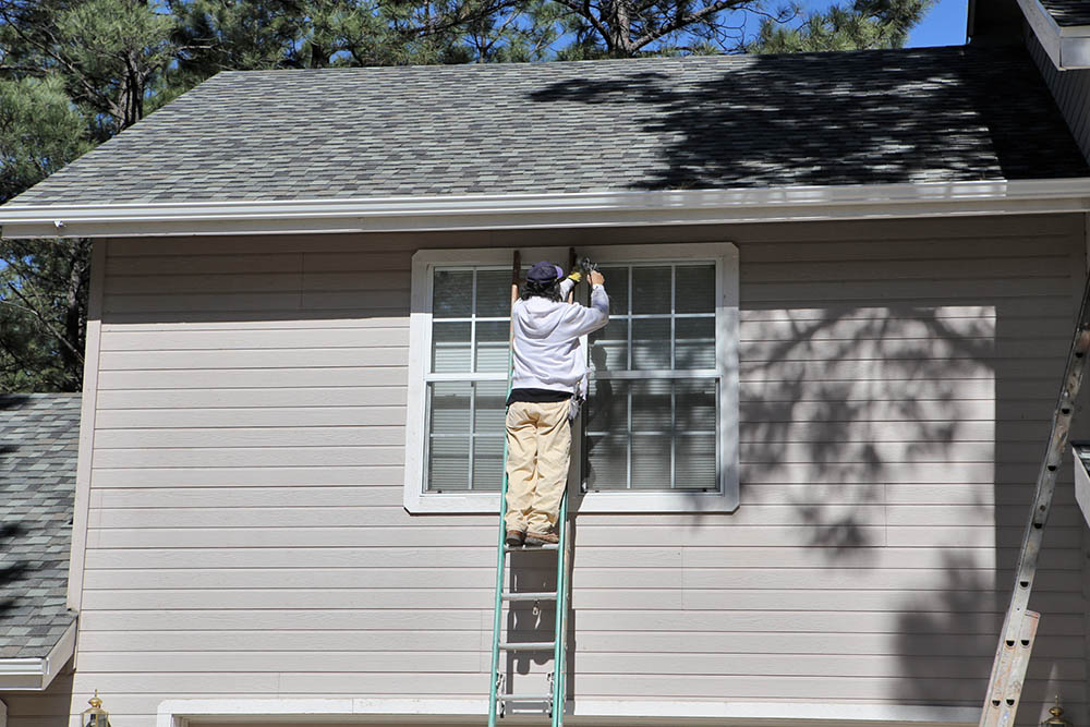Exterior Painting Caulking windows on an exterior paint job in Flagstaff AZ