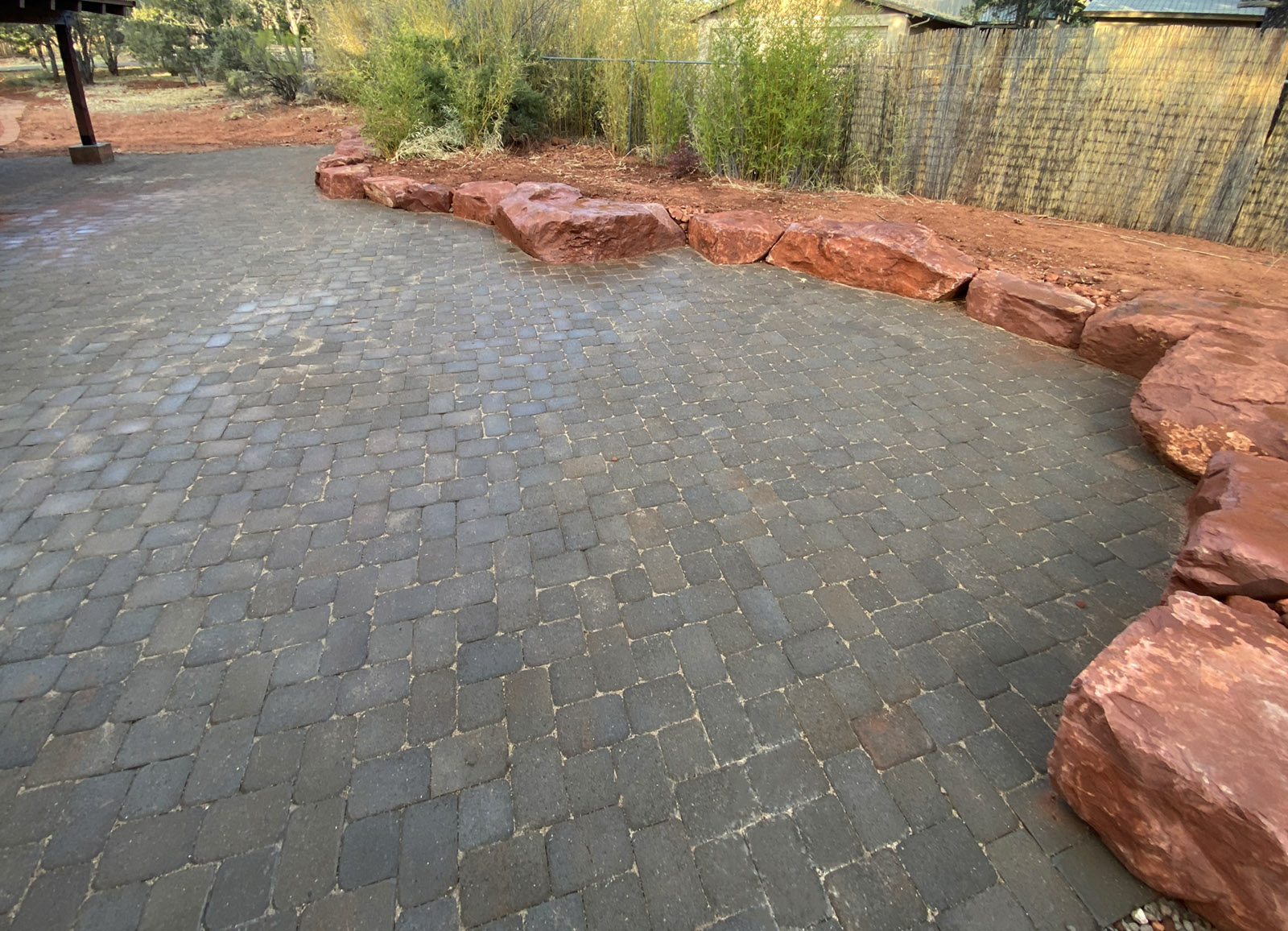 Paver patio surrounded on one side by natural seating boulders in Sedona Arizona