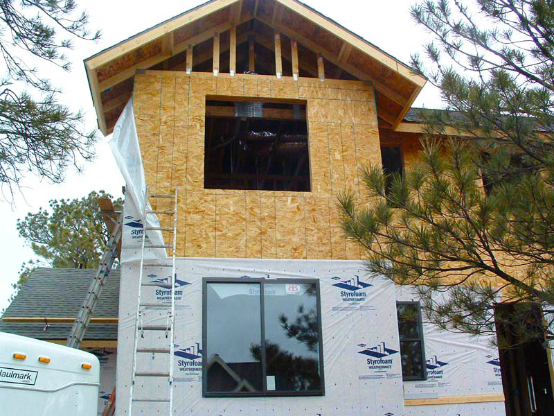 Installing house wrap in preparation for siding