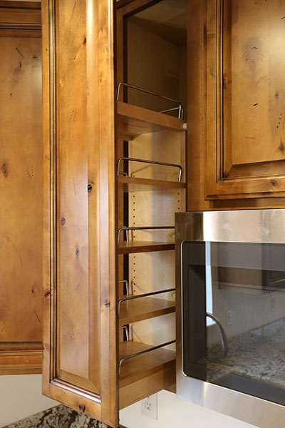 Upper spice rack in a set of Kitchen cabinets.